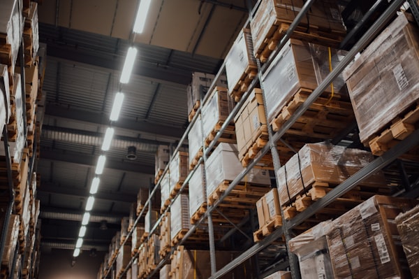 Forklift operator moving pallets in warehouse